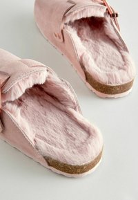 Rosa mockaskor med plyschfoder, texturerad innersula och korkyttersula. Har en remdetalj för en säker passform.