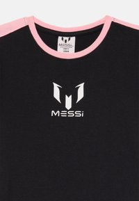 Sort bomulds t-shirt med lyserøde krave detaljer, prydet med et hvidt logo med stiliseret 'M' og teksten 'Messi' trykt på forsiden.