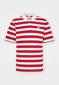 Röd och vit randig polo skjorta med krage och korta ärmar, med en liten Nike-logotyp på vänster bröstområde.