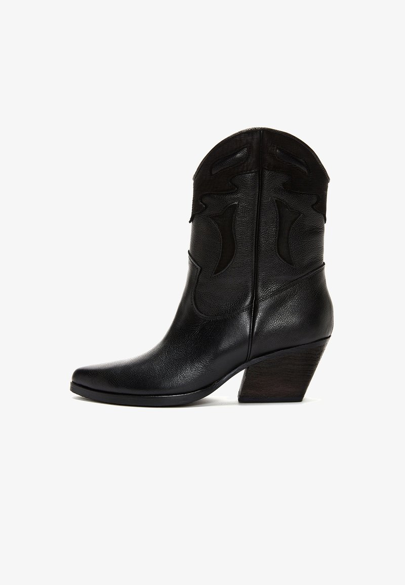 Zwarte leren cowboylaars tot halverwege de kuit met een gestructureerd bovenwerk, een spitse neus en een schuin opgebouwde houten hak op een witte achtergrond.