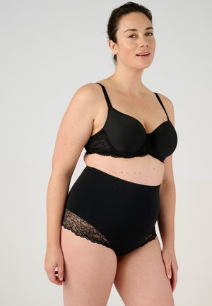 Conjunto de lencería negra que incluye un sujetador con copas moldeadas y detalles de encaje, junto con bragas de cintura alta con toques de encaje. Textura de tela suave en todo el conjunto.