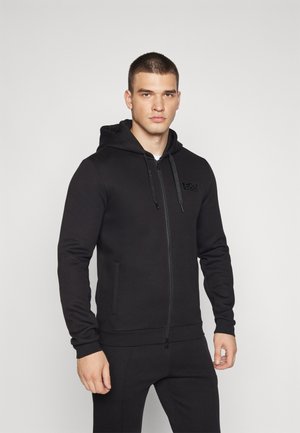 Felpa nera con zip realizzata in materiale morbido, con zip frontale, due tasche laterali e una toppa logo tono su tono sul petto.