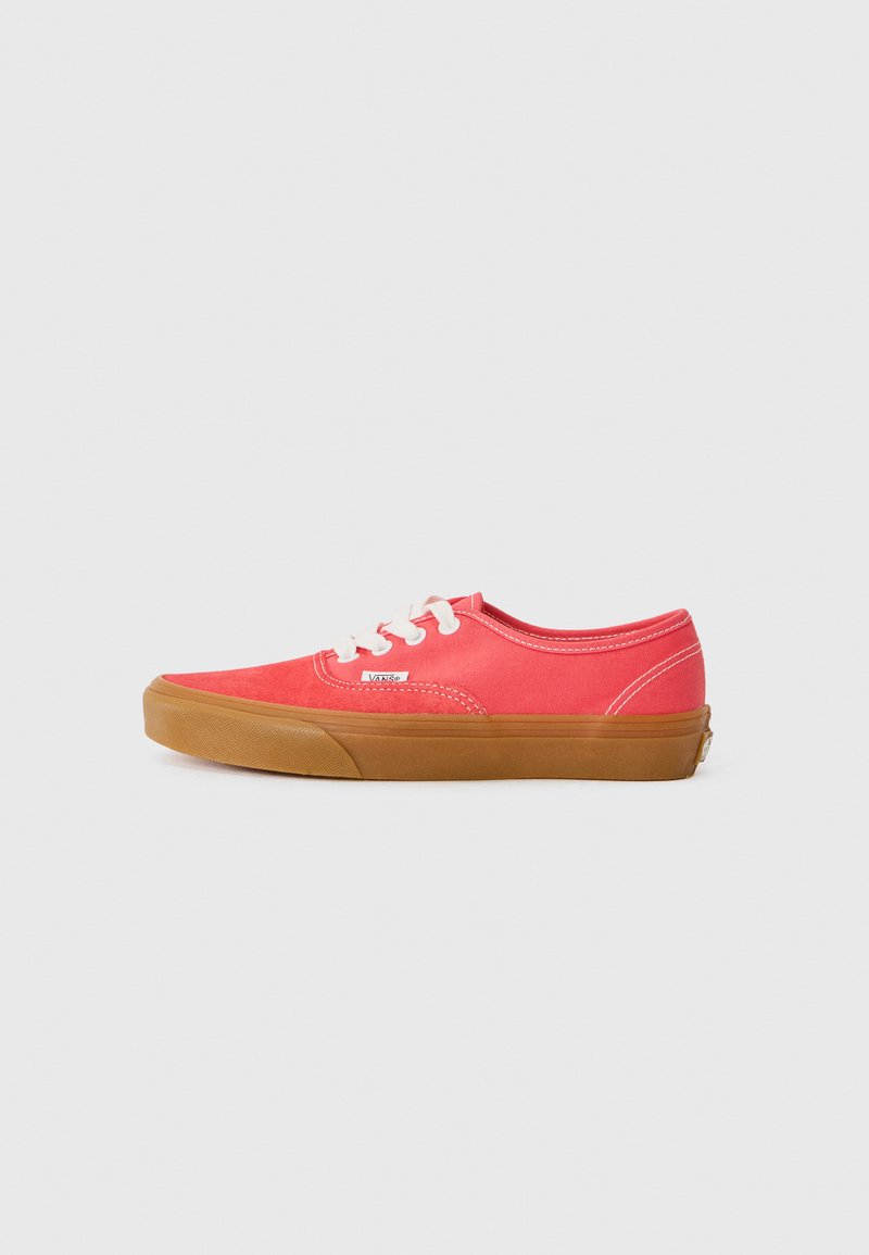 Red canvas sneakers with white laces, rubber gum sole, round toe, and stitched accents. Logo on the side near the sole.
