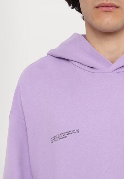 Sweatshirt lilás feito de algodão orgânico, com um capô grande e um pequeno detalhe em texto na parte da frente, textura suave e corte descontraído.