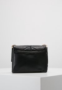 Borsa a tracolla nera in pelle con pattina trapuntata, tracolla in catena dorata, superficie liscia e tasca frontale per ulteriore spazio di archiviazione.