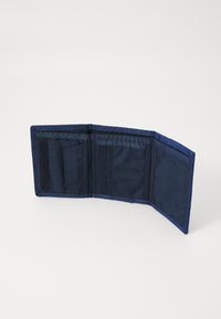Monedero azul marino con un exterior de tela, que cuenta con múltiples compartimentos para tarjetas, un bolsillo y un cierre de velcro, mostrado abierto.