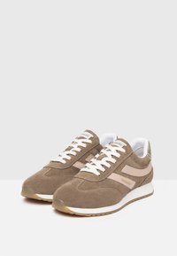 Baskets en daim marron avec des accents roses, des lacets blancs et une semelle blanche. Elles présentent un bout arrondi et un design supérieur texturé.