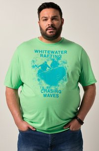 Light green cotton t-shirt with a graphic print of kayakers and text "WHITEWATER RAFTING CHASING WAVES" in bold blue letters.