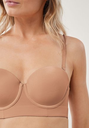 Reggiseno strapless leggermente imbottito di colore nude, con tessuto liscio, coppe sagomate e spalline regolabili. Linee pulite con hardware minimal.