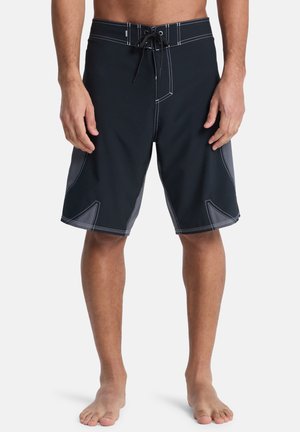 Black swim trunks with a drawstring waist, contrast stitching, and angular side panel accents in grey. Smooth texture, knee-length design.
