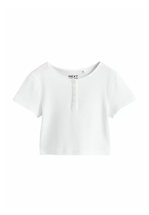 Biela krátka blúzka s krátkym rukávom z textúrovaného materiálu, s okrúhlym výstrihom a so štyrmi malými gombíkmi na prednej strane pod golierom.