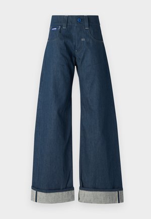 Džínsové nohavice s širokými nohavicami v tmavomodrej farbe, s pevným povrchom, srolovaným lemom v kontrastnej svetlomodrej farbe a prednými vreckami.