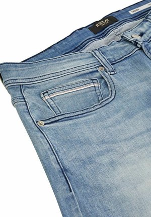 Jeans in denim blu chiaro con una texture liscia, dotati di una tasca frontale, cuciture in contrasto e un classico design a gamba dritta.