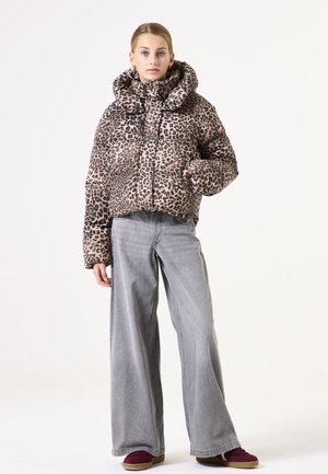 Jasje met luipaardprint, met een hoge kraag, lange mouwen en een cropped ontwerp, gecombineerd met grijze wijd uitlopende jeans en bordeauxrode schoenen.