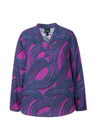 Chemise à manches longues en tissu violet avec des motifs de points turquoise et noir. Présente une coupe décontractée et un ourlet légèrement incurvé.