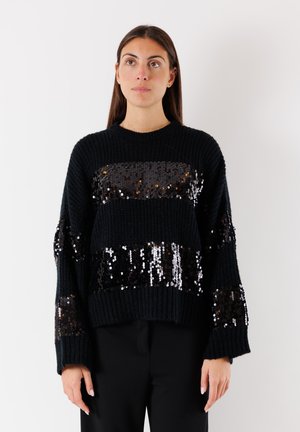 Maglione nero a maglia con strisce di paillettes, caratterizzato da una vestibilità ampia, polsini e orlo a costine. La texture comprende un motivo a maglia prominente.