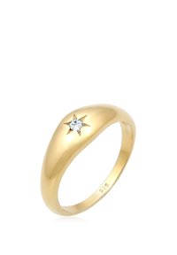 Anello color oro con una fascia liscia e arrotondata e un accento a forma di stella che presenta un singolo diamante al centro. Marchiato "925."