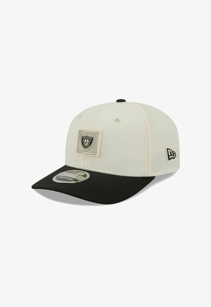 Weiße und schwarze Snapback-Cap mit Raiders-Logo-Patch vorne und New Era-Logo an der Seite, sichtbar vor weißem Hintergrund.