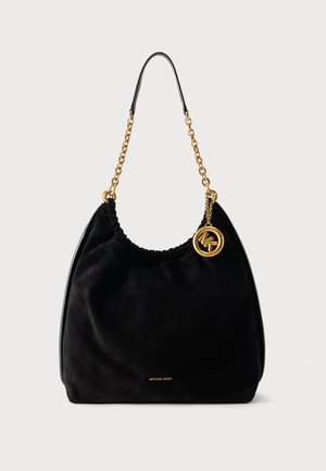 Black suede hobo bag with gold chain strap and circular gold MK logo charm, Michael Kors branding in small gold letters at base.