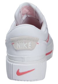 Baskets Nike avec une tige en toile blanche, des accents roses, un talon rembourré et une semelle en caoutchouc texturée avec un détail du logo.