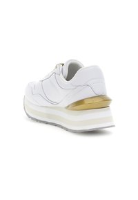 Sneaker bianca con tomaia testurizzata, accento dorato sul tallone, suola impilata bianca e beige spessa e suola in gomma grigia.