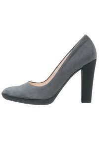 Chaussure à talon haut en suède gris avec un bout arrondi et un talon épais noir, arborrant une texture lisse et un design minimaliste.