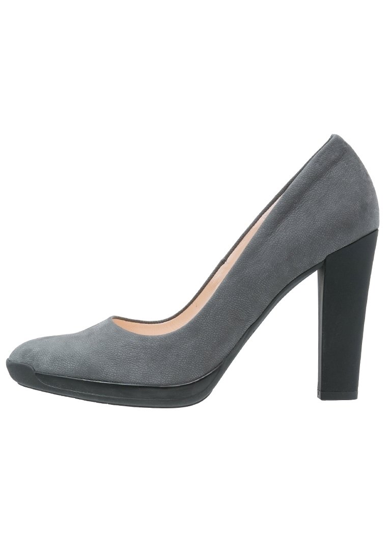 Chaussure à talon haut en suède gris avec un bout arrondi et un talon épais noir, arborrant une texture lisse et un design minimaliste.