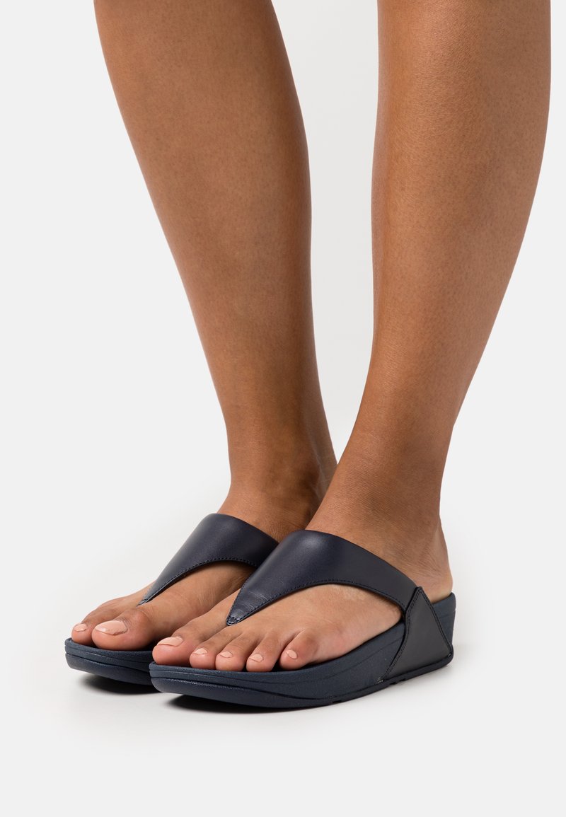 Mørkeblå lær flip-flops med et v-formet toppstropp, polstret såle og en bred base for stabilitet. Åpen tå-design med minimal maskinvare.