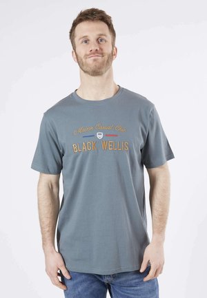 T-shirt bleu clair en coton, avec le texte brodé "MAISON CASUAL CHIC BLACK WELLIS" en doré et rouge, de conception col rond.