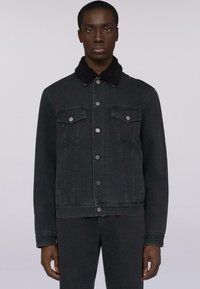 Giacca in denim nera con colletto testurizzato nero, chiusura frontale con bottoni e due tasche sul petto. Presenta un design aderente e un taglio dritto.