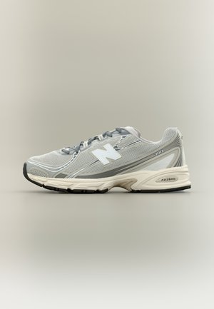 Hellgrauer und weißer New Balance 740 Laufschuh mit Mesh-Obermaterial, grauen Schnürsenkeln und gepolsterter weißer Zwischensohle mit schwarzer Außensohle.