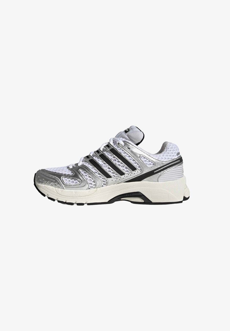 Chaussure de sport blanche et argentée avec des rayures noires, une tige en mesh, une semelle rembourrée et un design à lacets, présentée en profil sur un fond blanc.