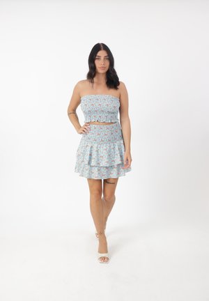 Lichtblauw tweedelig set met bloemmotief. Strapless top en een uitlopende rok met een gerimpelde zoom. Glad materiaal met elastische details.