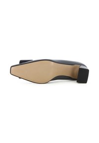 Scarpa nera con tacco quadrato, con tomaia liscia, punta squadrata e suola beige antiscivolo. Presenta elementi di design minimalisti.