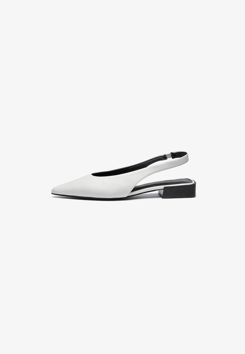 Bela usnjena ženská obuv s slingback dizajnom, s koničastim nosom, odprtim dizajnom na peti in nizkim črnim blokom peto. Gladka tekstura, minimalni poudarki.