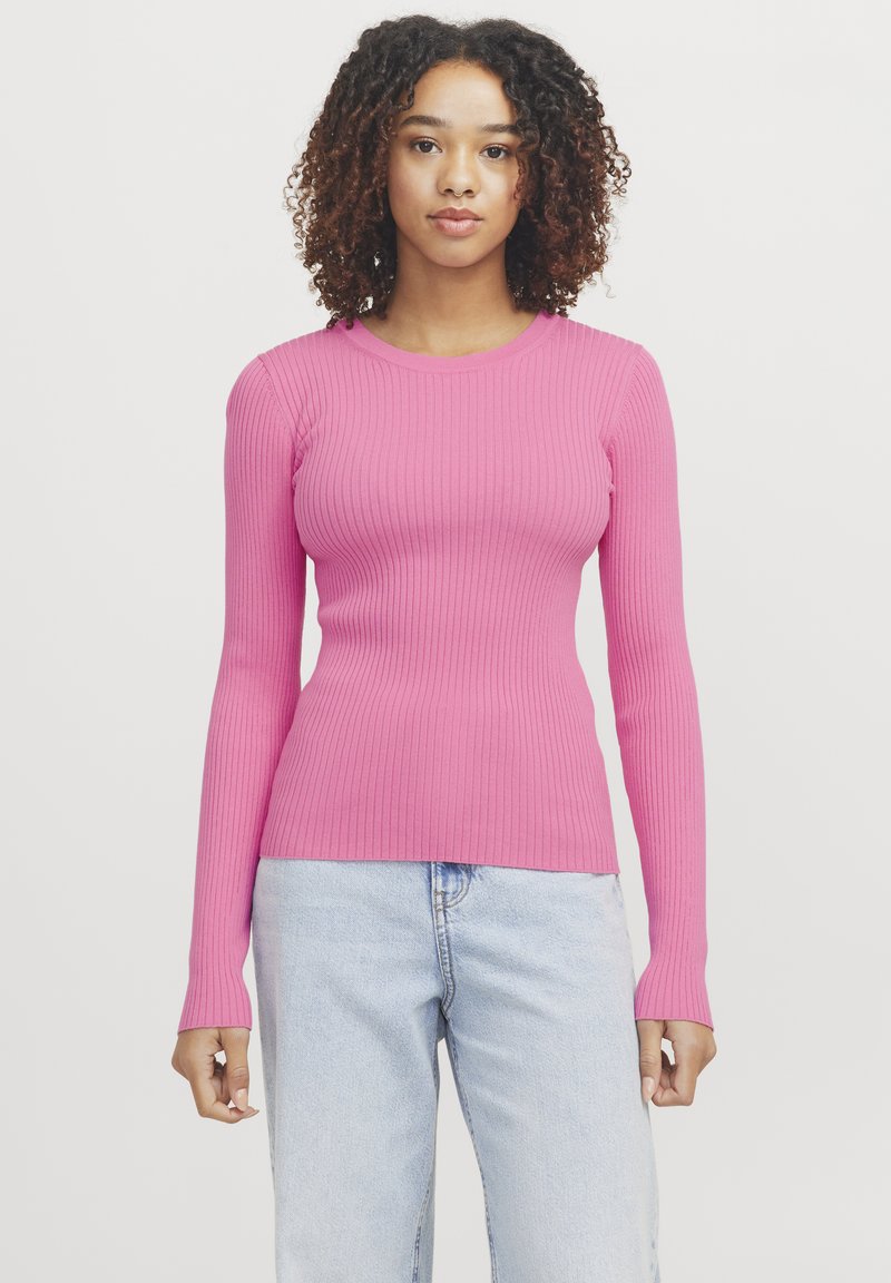 Top de manga larga acanalado en rosa brillante, con un diseño ajustado y cuello redondo; combinado con unos jeans de color azul claro.