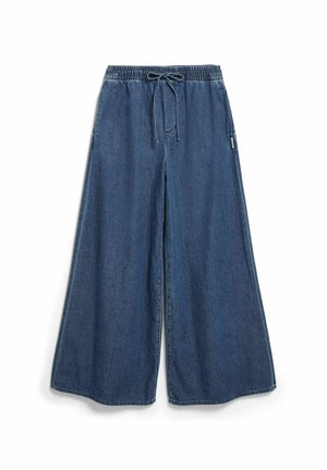 Weit geschnittene blaue Jeanshose mit elastischem Bund und Kordelzug, Nahtdetail an der Vorderseite und Seitentaschen, flach auf weißem Hintergrund ausgelegt.