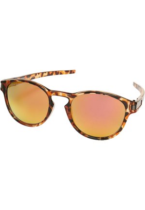 Lunettes de soleil en écaille de tortue avec des montures rondes, des verres roses réfléchissants et des branches fines conçues pour une sensation de légèreté.