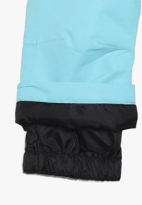 Manga de chaqueta azul claro con puño interno negro elástico para protección contra el clima.