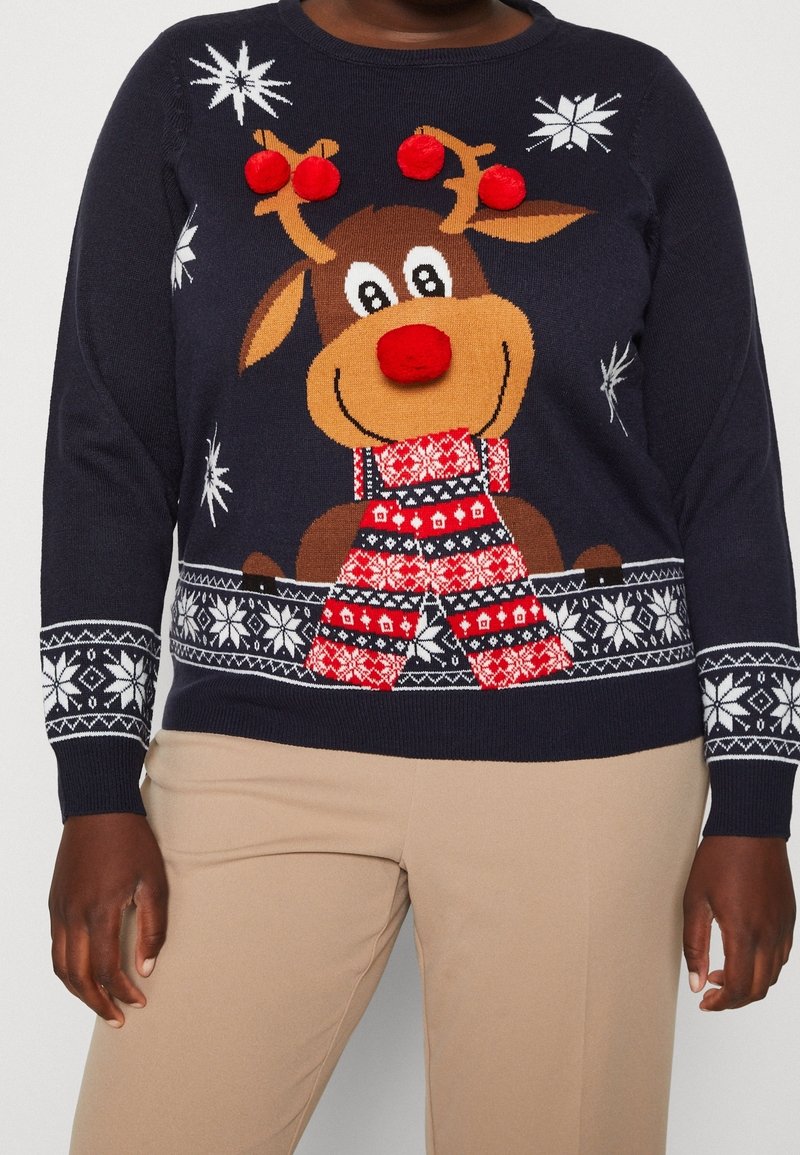 Pull bleu marine avec un renne souriant portant une écharpe rouge, un nez à pompon rouge et des bois, entouré de flocons de neige blancs et de poignets à motifs.