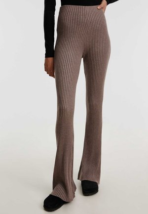 Geribbelde, hoog getailleerde flared pants in een gedempte bruin tint, gemaakt van een zachte gebreide stof. Aangevuld met een lichte flair aan de onderkant.