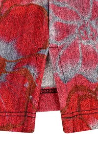 Strickstoff in Schattierungen von Rot und Pink mit grauen Akzenten. Verfügt über ein strukturiertes Muster und einen kleinen Schlitz am Saum, gefüttert im Inneren.