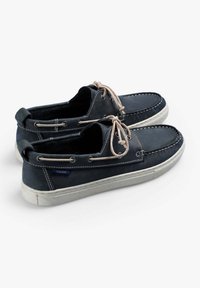 Granatowe skórzane buty żeglarskie z jasnymi sznurówkami, okrągłym noskiem, białą gumową podeszwą i kontrastującymi detalami szewnymi. Z akcentem w postaci metki z logo.
