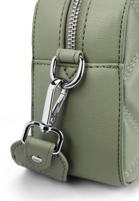 Zelená kožená kabelka s kovovým zipem a hardwarem stříbrné barvy, s akcenty v podobě prošívání a strukturovaným obdélníkovým tvarem.