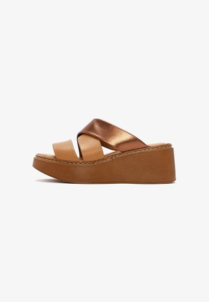 Sandales compensées marron avec des lanières croisées en cuir métallique cuivre et en cuir matte tan. Présente une semelle épaisse et texturée avec des coutures contrastées.