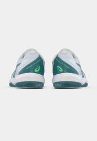 Witte sportschoenen met groene accenten, een bovenwerk van structuurmesh, gevoerde kraag en rubberen zolen met een zigzagpatroon.