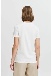 T-shirt en coton blanc à manches courtes et col rond, présentant un design simple et classique avec une texture douce. Vue arrière uni.