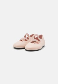 Scarpe in pelle rosa chiaro con punta arrotondata, lati con ritagli e fasce elastiche incrociate. Texture liscia e suola nera piatta.