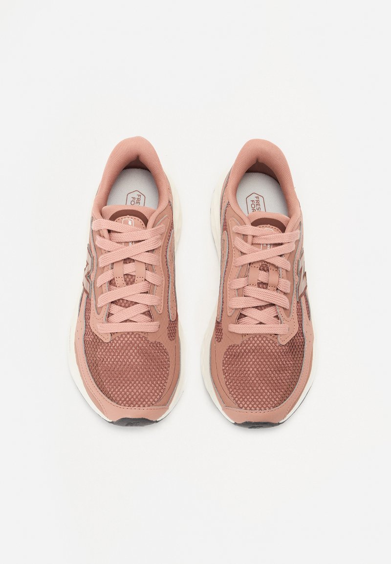 Rosa Netzsneaker mit strukturierten Paneelen, abgerundeten Zehen und Schnürdesign. Verfügt über eine weiße Sohle und Markierung an den Seiten.