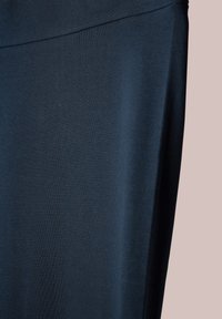 Tejido azul marino, textura suave, material elástico, presenta una cintura alta y parece ser parte de una prenda como leggings o pantalones de yoga.
